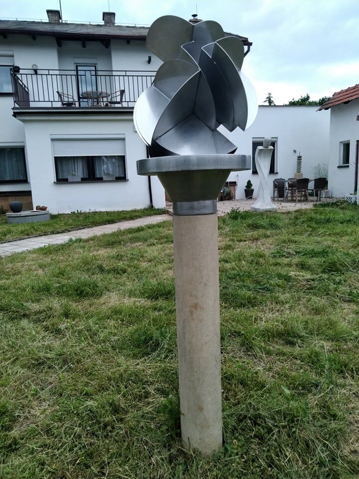 Umělecká socha kvetu z nerezové oceli a podstavce z přírodního pískovce.