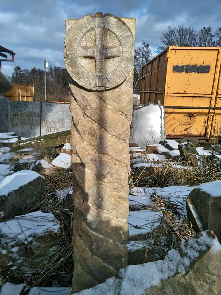Patník s reliéfem kříže, který je vytvořený z přírodního pískovce.