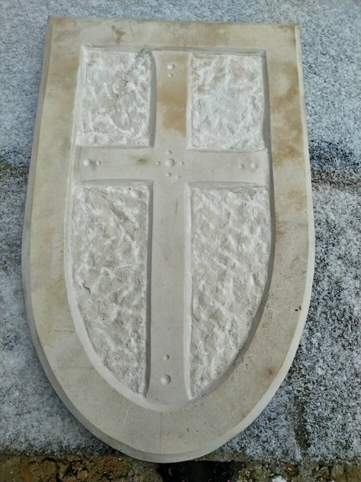 Křižácký kříž z vápence ve tvaru erbu.