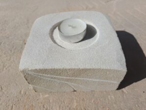 Broušený svícen ve tvaru čtverce, který je vytvořený z&nbsp;přírodního pískovce.