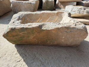 Menší a&nbsp;nižší květináč z&nbsp;přírodního pískovce, který tvarem připomíná obdélník.